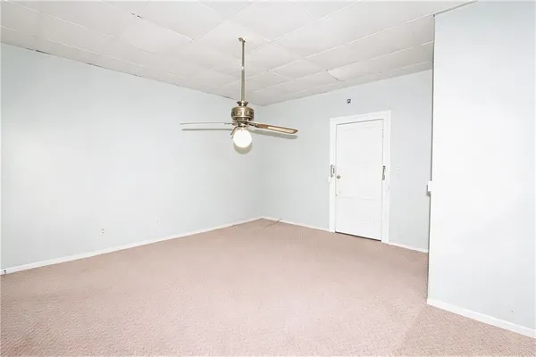 an empty room with a chandelier fan