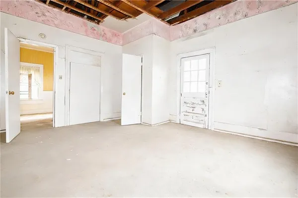 an empty room with windows and closet