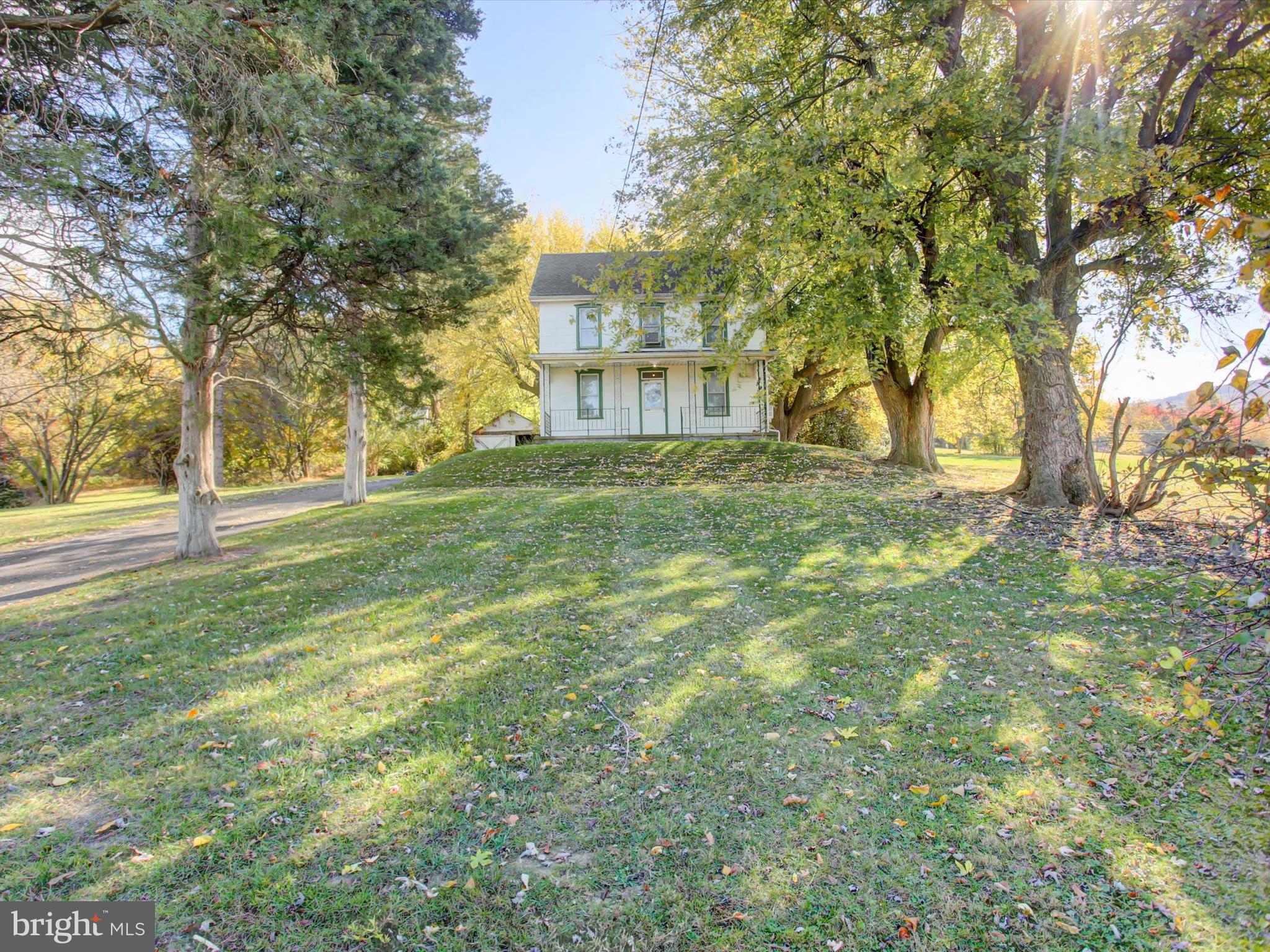 a view of a big yard with a house and large trees