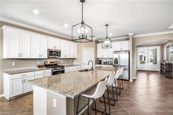a kitchen with stainless steel appliances granite countertop a kitchen island a stove a table and chairs in it
