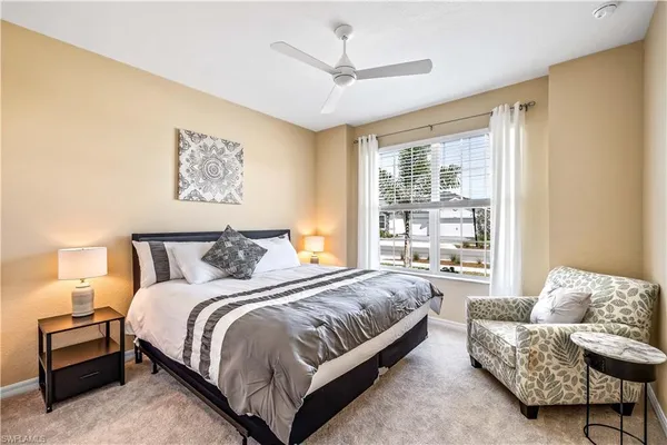 a spacious bedroom with a bed couch and a large window