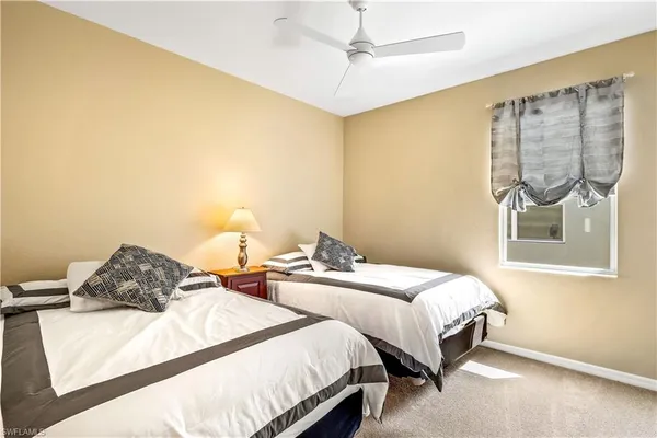 a bedroom with two beds and a chandelier