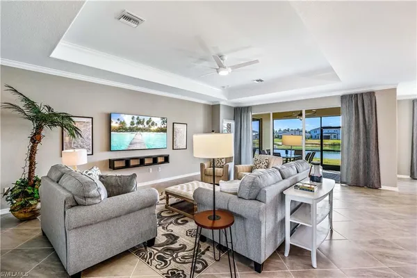 a living room with furniture a chandelier and a potted plant
