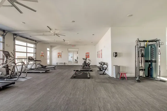 a living room with furniture gym equipment and a large window