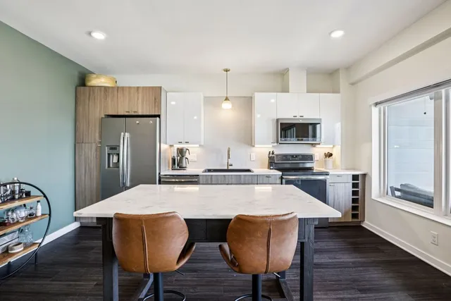 a living room with furniture and a view of kitchen
