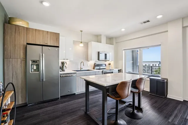 a large kitchen with a table and chairs