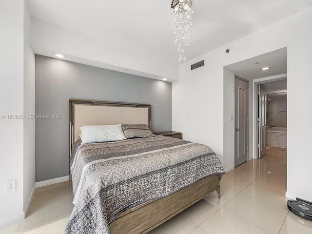 a bedroom with bed and a chandelier