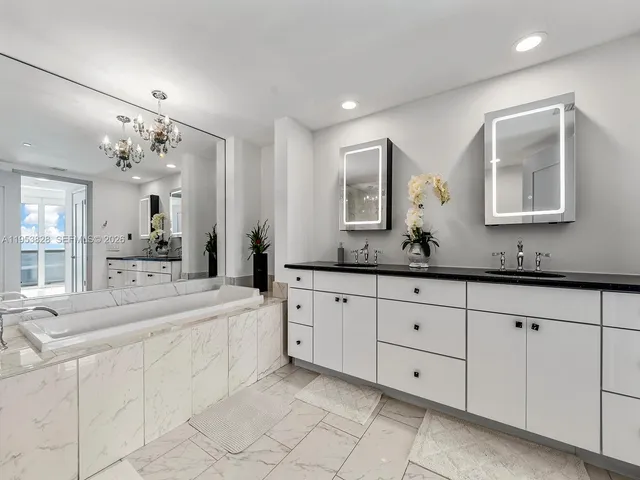 a spacious bathroom with a granite countertop sink mirror and bathtub