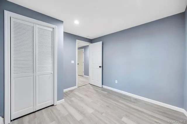 a bedroom with a bed a mirror and a window