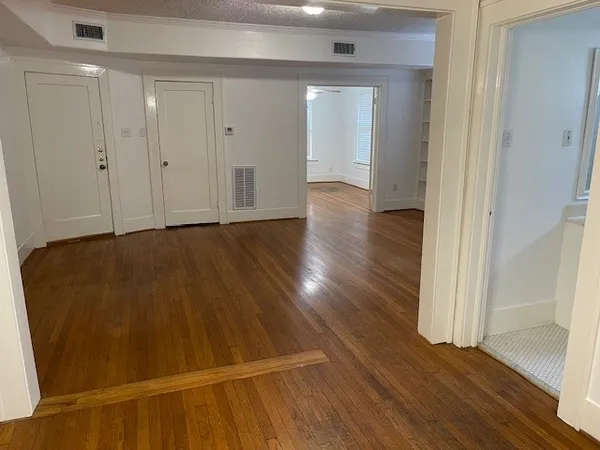 a view of an empty room with wooden floor
