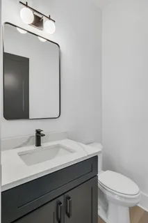 a bathroom with a toilet sink and mirror