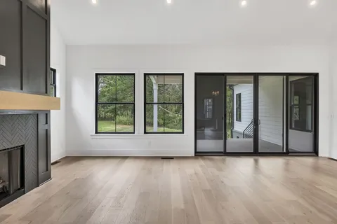 a view of a livingroom with wooden floor and a fireplace