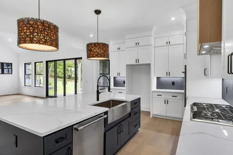 a kitchen with stainless steel appliances granite countertop a sink a stove and a refrigerator