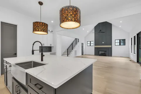 a large kitchen with a stove a kitchen island a sink stainless steel appliances and cabinets