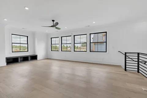a view of a livingroom with a ceiling fan and wooden floor