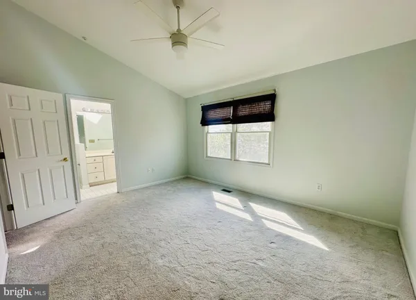 an empty room with a ceiling fan and a window