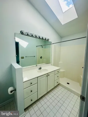 a spacious bathroom with a vanity sink and a mirror