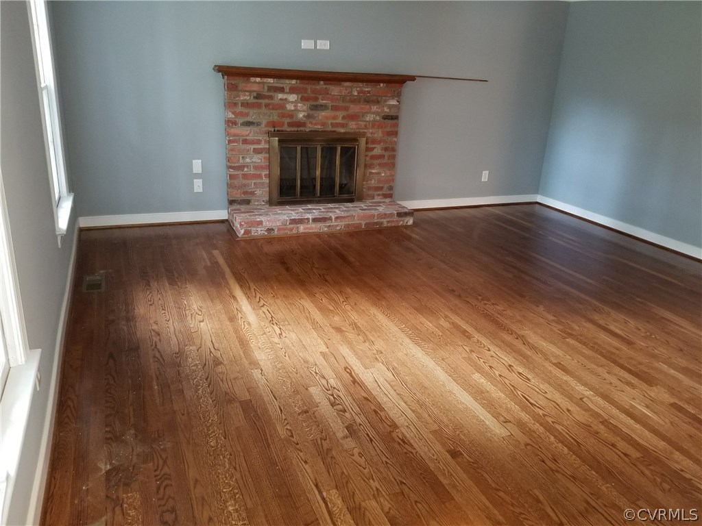 4117 Cresthill Road Chester, VA 23831 - Photo 21 of 40 an empty room with wooden floor and fireplace