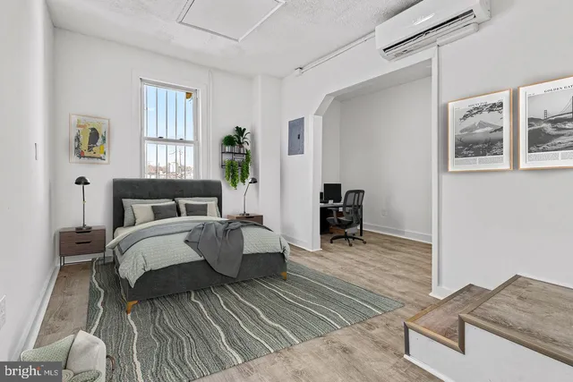 a bedroom with a bed and a dresser next to a window