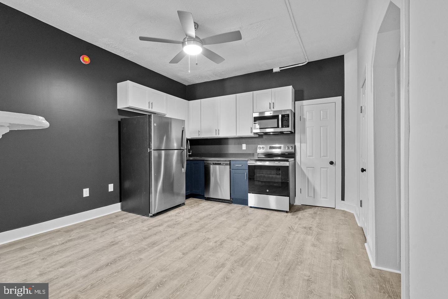 1308 West Lexington Street, Unit 3R Baltimore, MD 21223 - Photo 4 of 16 a kitchen with stainless steel appliances a refrigerator and a stove top oven