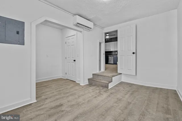 a view of empty room with wooden floor and cabinet