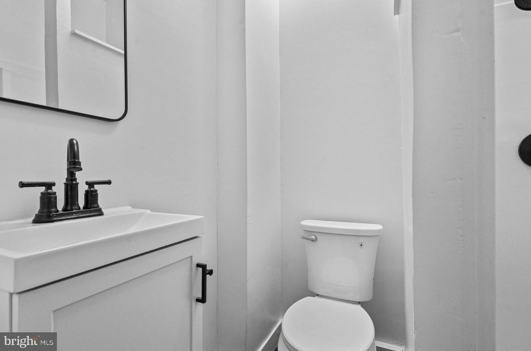 1308 West Lexington Street, Unit 3R Baltimore, MD 21223 - Photo 8 of 16 a bathroom with a toilet sink and mirror