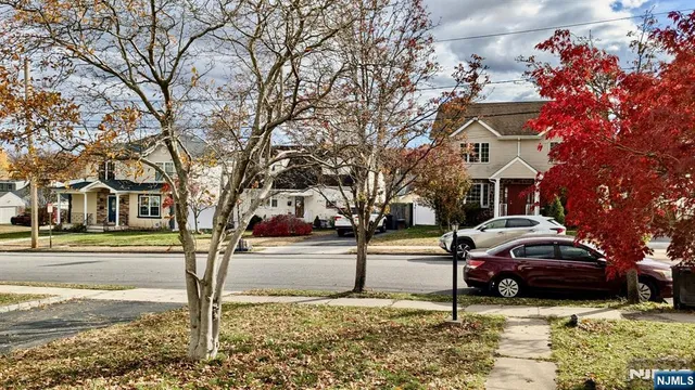 a front view of a house with a yard covered with snow and trees