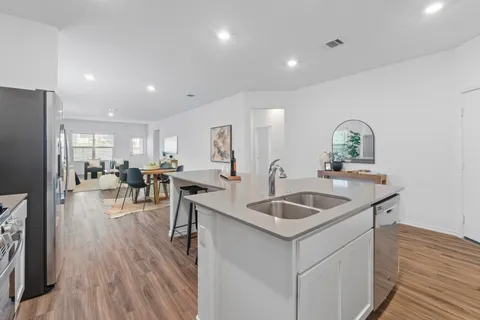 a kitchen with center island white cabinets and stainless steel appliances