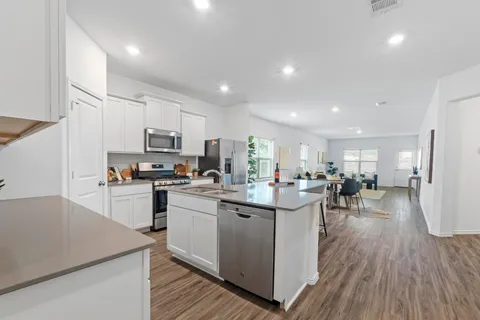 a kitchen with a sink a counter top space stainless steel appliances and cabinets