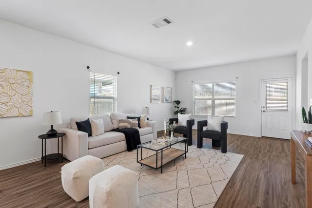 a living room with furniture and wooden floor