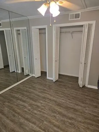 an empty room with wooden floor and window