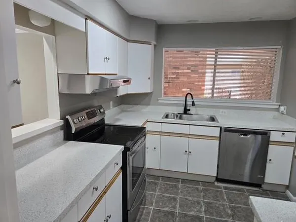 a kitchen with a sink stove and cabinets
