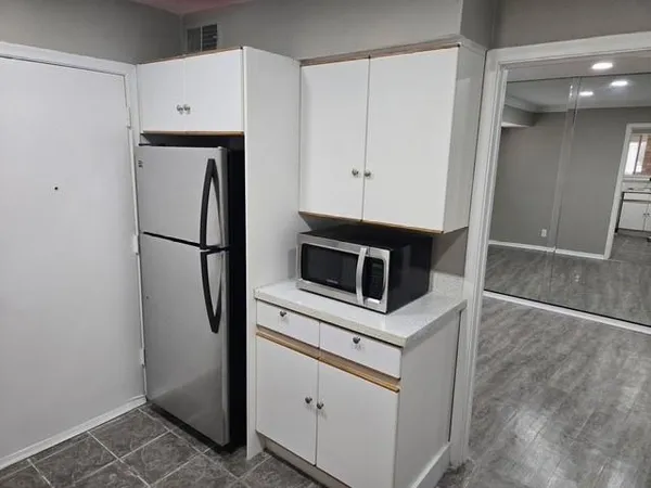 a kitchen with white cabinets and white appliances