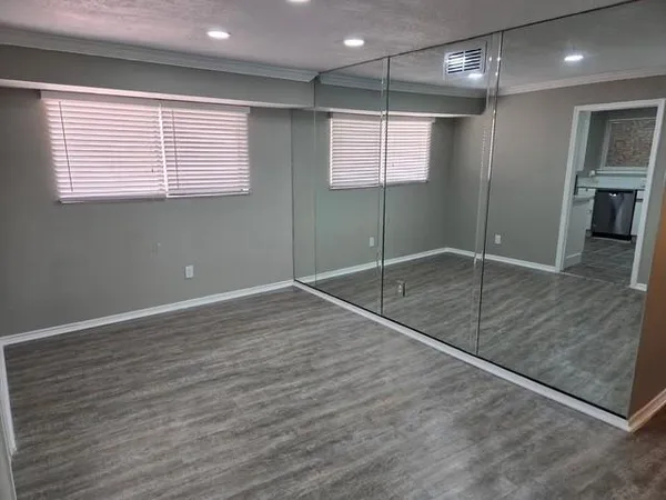 an empty room with wooden floor and a window