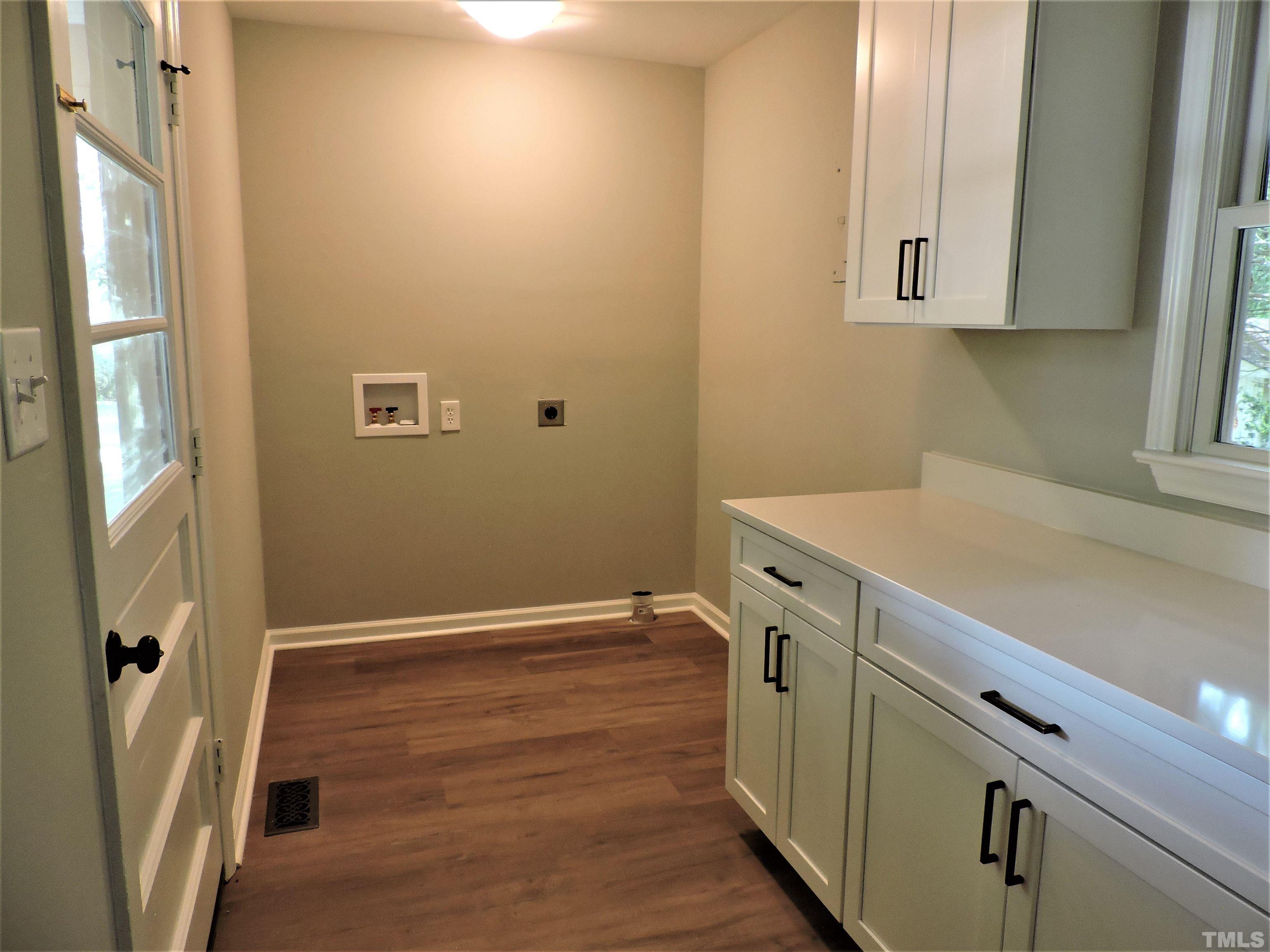 1513 Ridge Lane Hillsborough, NC 27278 - Photo 23 of 24 a view of a kitchen with white cabinets and wooden floor