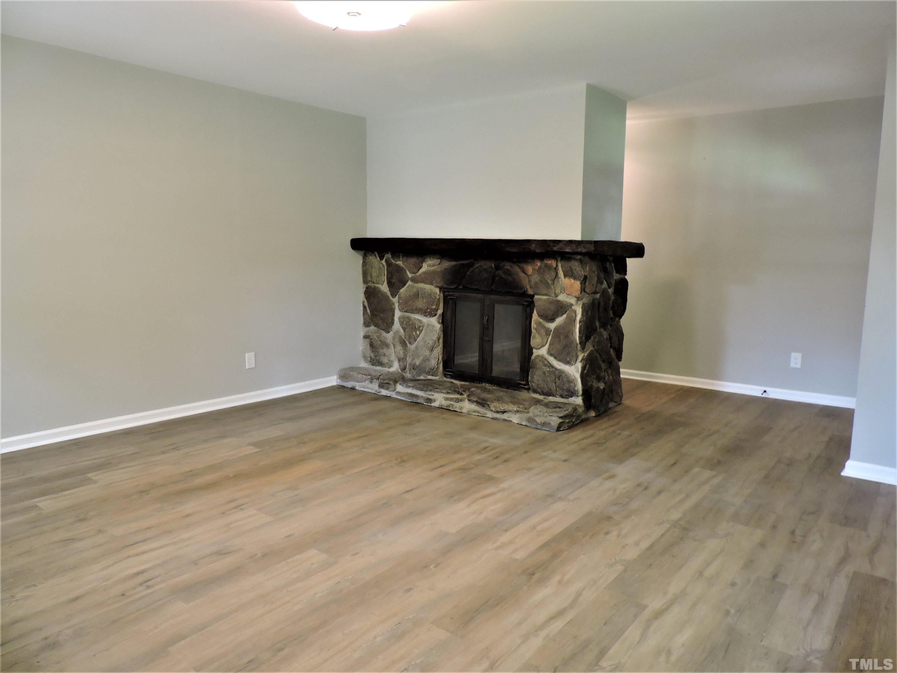 1513 Ridge Lane Hillsborough, NC 27278 - Photo 8 of 24 a view of an empty room with wooden floor and a fireplace