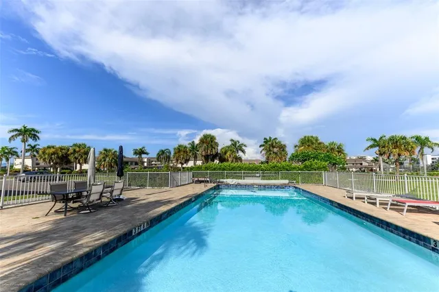 a view of a swimming pool with a yard and sitting area