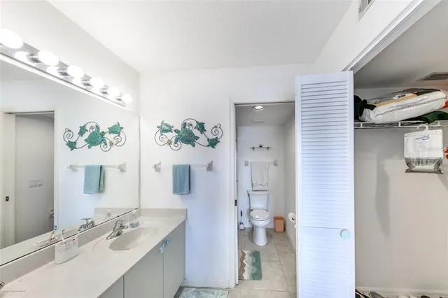 a bathroom with a sink vanity mirror and toilet