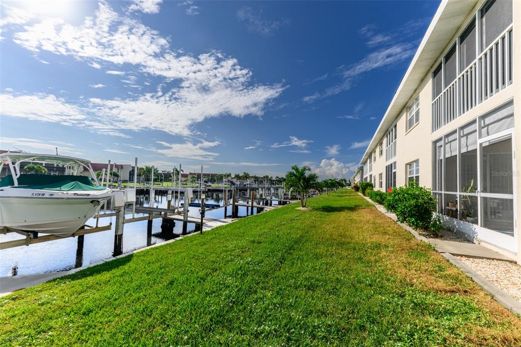 220 Coldeway Drive, Unit 112 Punta Gorda, FL 33950 - Photo 44 of 49 a view of a garden with a bench in front of house