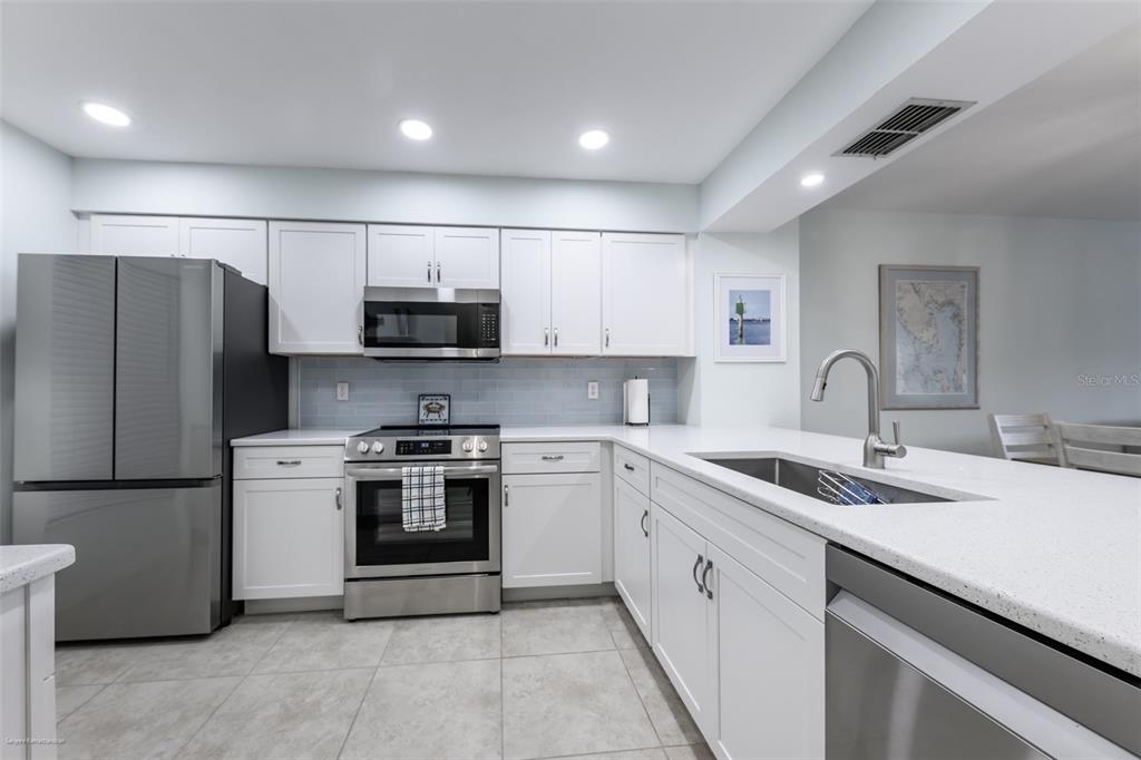 220 Coldeway Drive, Unit 112 Punta Gorda, FL 33950 - Photo 5 of 49 a kitchen with stainless steel appliances granite countertop a sink a stove a refrigerator and a microwave