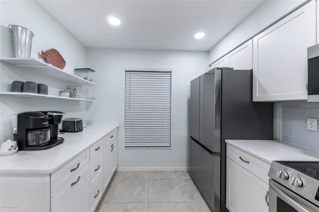 a kitchen with stainless steel appliances white cabinets and a refrigerator
