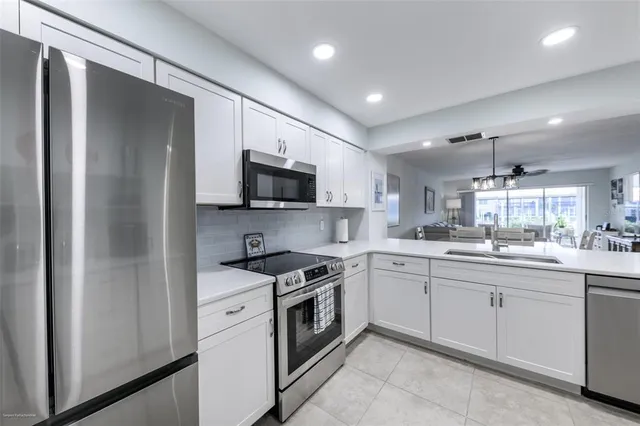 a kitchen with a sink stainless steel appliances and white cabinets