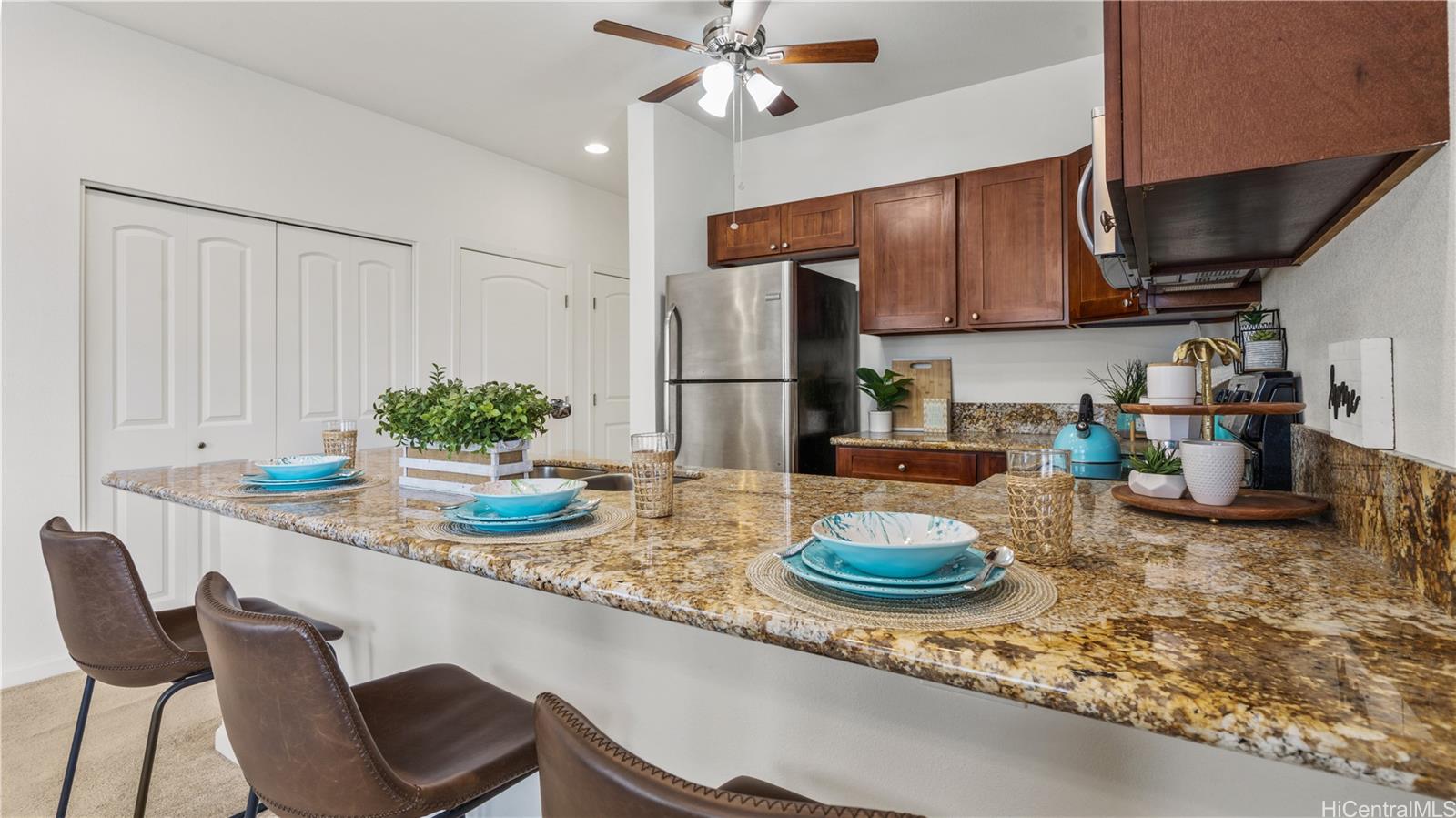 87-176 Maipalaoa Road, Unit J23 Waianae, HI 96792 - Photo 1 of 1 a kitchen with stainless steel appliances granite countertop a sink a stove and chairs