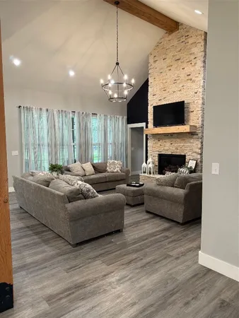 a living room with furniture a fireplace and a flat screen tv