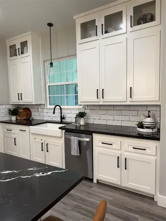 a kitchen with granite countertop white cabinets and white appliances