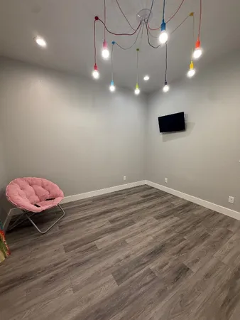a view of a room with wooden floor and fan