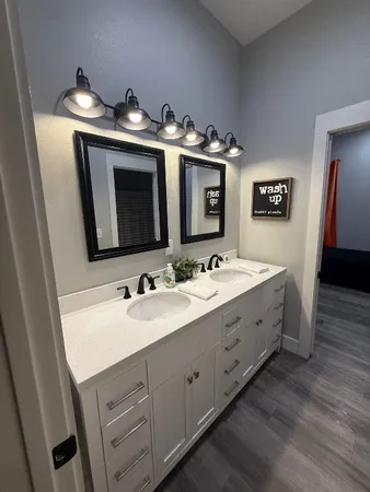 a bathroom with double sink and two mirror