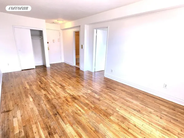 a view of empty room with wooden floor