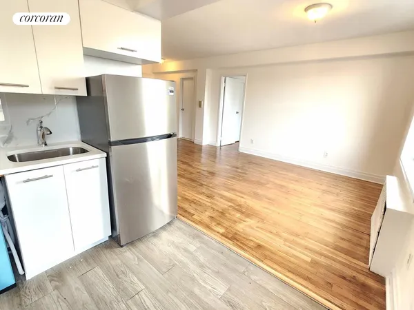 a view of a kitchen with refrigerator and a sink