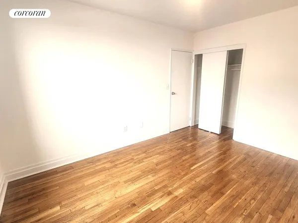 a view of empty room with wooden floor